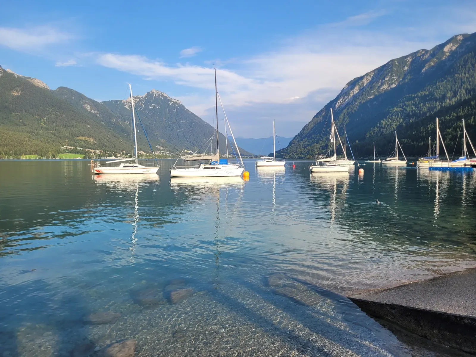 Vitorlások a türkizkék Achensee-n Pertisau előtt, háttérben hegyek